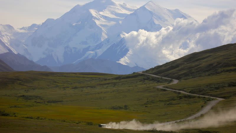 In this photograph taken Thursday, Aug. 8, 2013,, a tour bus kicks up dust during a sunny day at Denali National Park in Alaska as Mount Denali appears in the background. Three Orem firefighters were dispatched to the Anderson Complex fires, city officials said Monday.