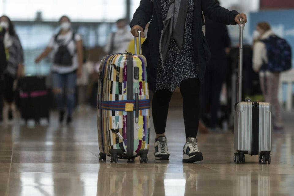 Passengers carry suitcases at Berlin Brandenburg Airport (BER) on July 1, 2021, in Schoenefeld, Germany. (Photo by Maja Hitij/Getty Images)