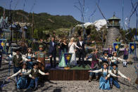 Paul Chan, Hong Kong's financial secretary, left, and Josh D'Amaro, chairperson of Disney Experiences, right, pose with performers in front of the press during the opening ceremony of the World of Frozen themed area at Disneyland Resort in Hong Kong, Monday, Nov. 20, 2023. (AP Photo/Louise Delmotte)