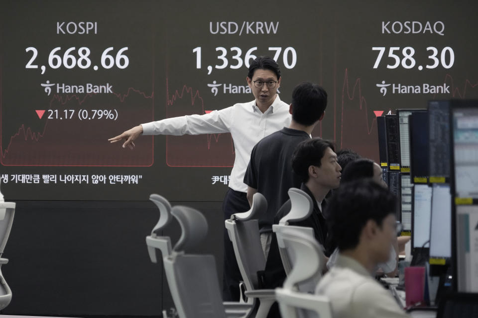 Currency traders work near a screen showing the Korea Composite Stock Price Index (KOSPI), top left, and the foreign exchange rate between U.S. dollar and South Korean won, top center, at the foreign exchange dealing room of the KEB Hana Bank headquarters in Seoul, South Korea, Thursday, Aug. 29, 2024. (AP Photo/Ahn Young-joon)