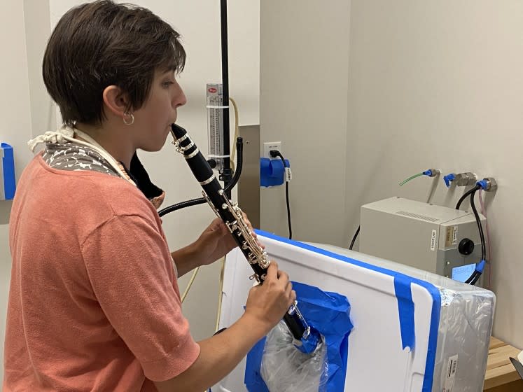 Researcher Tehya Stockman plays a clarinet in a University of Colorado Boulder lab to measure aerosol output.