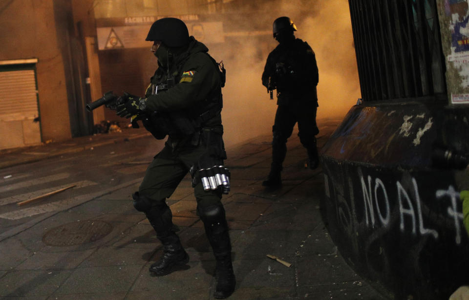 A riot police prepares to launch tear gas to disperse protesters who are against the reelection of President Evo Morales, in La Paz, Bolivia, Thursday, Oct. 31, 2019. Violence has escalated since Morales was declared the winner of the Oct. 20 vote amid delays in the vote count. The opposition alleges the outcome was rigged to give Morales enough of a majority to avoid a runoff election; the president denies any irregularities. (AP Photo/Juan Karita)