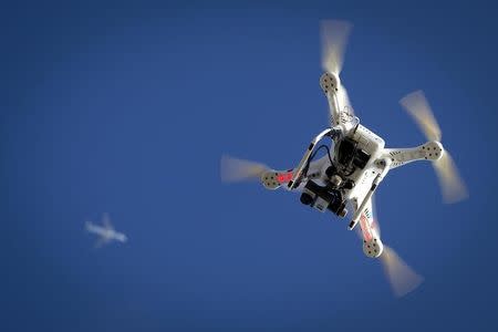 An airplane flies over a drone during the Polar Bear Plunge on Coney Island in the Brooklyn borough of New York January 1, 2015. REUTERS/Carlo Allegri