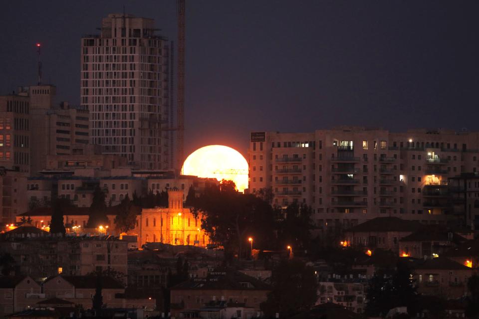 <p>The moon sets behind the city of Jerusalem early on Jan. 31, 2018. (Photo: Menahem Kahana/AFP/Getty Images) </p>