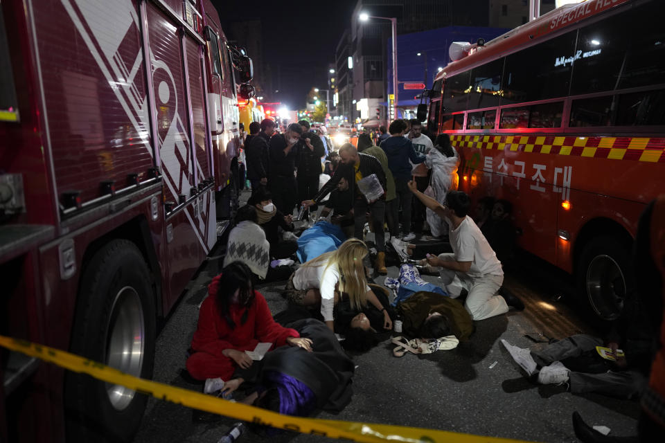 FILE - Injured people are helped at a street near the scene of a crush in Seoul, South Korea, on Oct. 30, 2022. South Korea’s parliament on Thursday, May 2, 2024 approved legislation mandating a new, independent investigation into the 2022 Halloween crush in Seoul that killed 159 people. (AP Photo/Lee Jin-man, File)