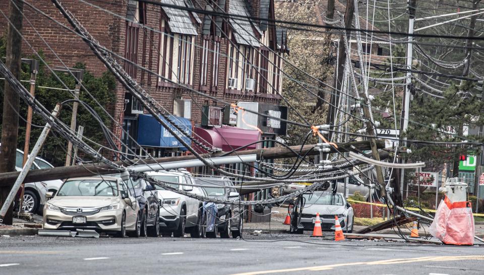 A utility pole and power lines lie across cars on Central Ave. in Greenburgh April 4, 2024 after heavy winds and rain caused damage and power outages in parts of the Lower Hudson region. Central Ave. remained closed through the morning.