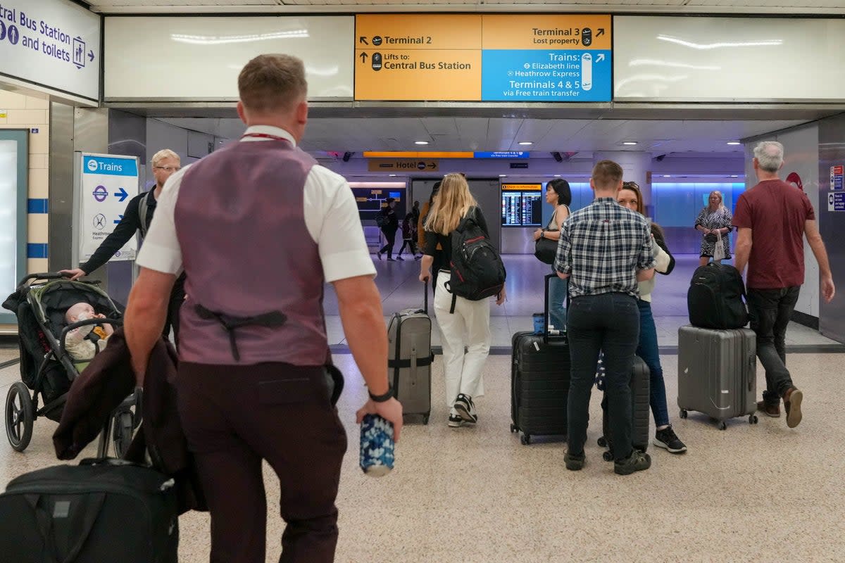 Passengers walk with their luggage to Heathrow Terminal 3 in London (REUTERS)