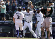 Seattle Mariners' Jacob Nottingham, center, and J.P. Crawford, right, greet Donovan Walton at home after he hit a three-run home run during the fourth inning of a baseball game, Monday, May 31, 2021, in Seattle. (AP Photo/John Froschauer)