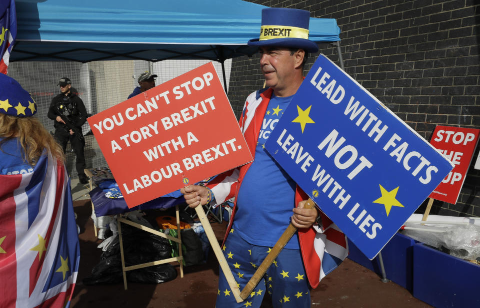 Anti Brexit campaigner Steve Bray holds banners outside the entrance to the Labour Party Conference at the Brighton Centre in Brighton, England, Monday, Sept. 23, 2019. (AP Photo/Kirsty Wigglesworth)