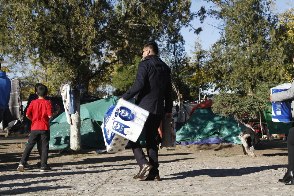 Alfredo López lleva papel higiénico donado a un campamento de migrantes levantado en un parque público de Ciudad Juárez, México, el 3 de diciembre del 2019. (AP Photo/Cedar Attanasio)