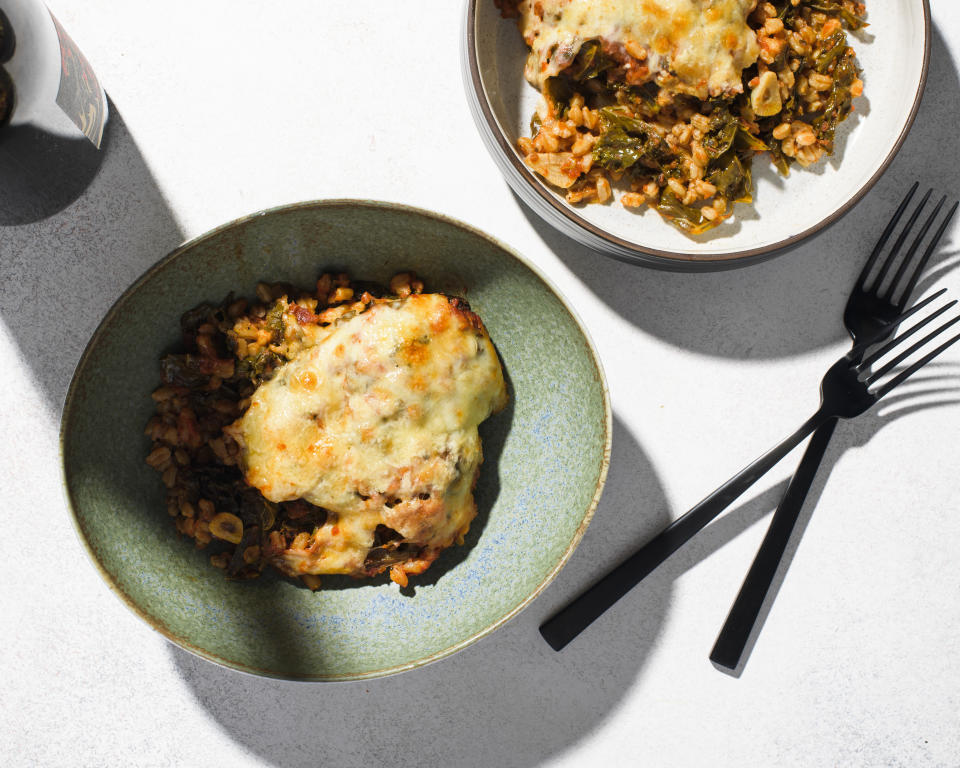 This image released by Milk Street shows a recipe for cheese baked farro with kale and tomatoes. (Milk Street via AP)