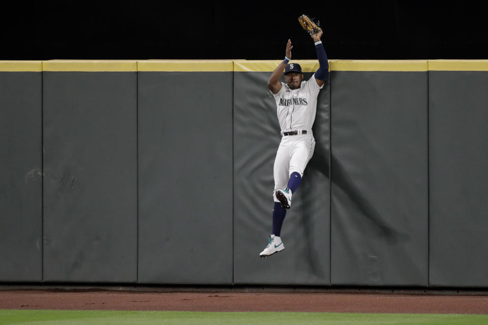Seattle Mariners right fielder Kyle Lewis makes a leaping catch at the wall of a fly ball hit by Los Angeles Angels' Jason Castro during the seventh inning of a baseball game Tuesday, Aug. 4, 2020, in Seattle. (AP Photo/Ted S. Warren)