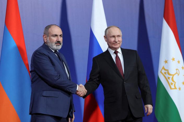 Armenian Prime Minister Nikol Pashinyan and Russian President Vladimir Putin shake hands as they attend the Collective Security Treaty Organization (CSTO) summit in Yerevan, Armenia, November 23, 2022.