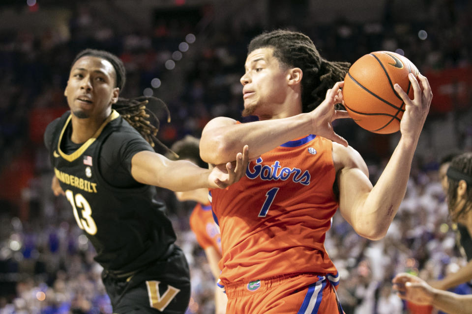 Vanderbilt guard Tyrin Lawrence (0) drives on Florida center Micah Handlogten (3) during the first half of an NCAA college basketball game, Saturday, Feb. 24, 2024, in Gainesville, Fla. (AP Photo/Alan Youngblood)