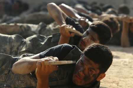 Rebel fighters demonstrate with their fake weapons during a military display as part of a graduating ceremony at a camp in eastern al-Ghouta, near Damascus August 31, 2014. REUTERS/Bassam Khabieh