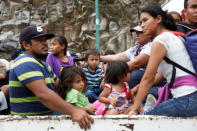 Honduran migrants, part of a caravan trying to reach the U.S., are pictured on a truck during a new leg of their travel in Zacapa, Guatemala October 17, 2018. REUTERS/Edgard Garrido