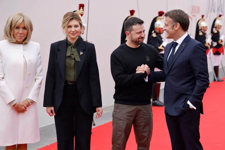 La esposa del presidente francés, Brigitte Macron, y el presidente de Francia, Emmanuel Macron, saludan al presidente de Ucrania, Volodimir Zelensky, y a su esposa, Olena Zelenska, a su llegada para asistir a la ceremonia en la playa de Omaha para conmemorar el 80º aniversario del Mundial. 