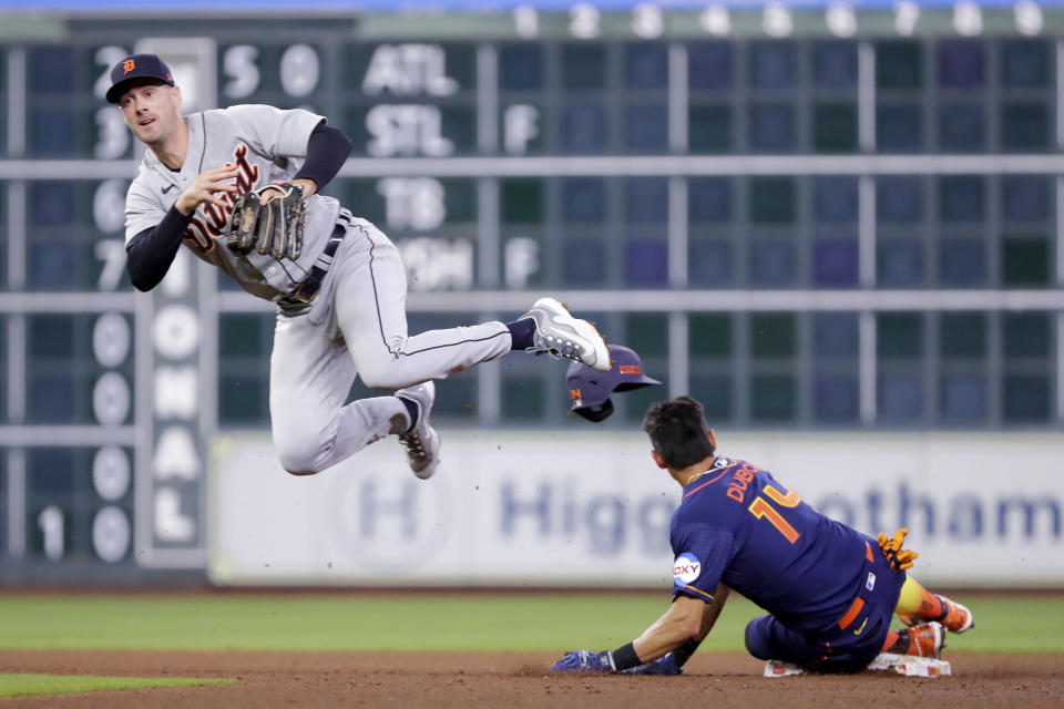 Detroit Tigers shortstop Ryan Kreidler, left, jumps to avoid the collision at second base as he turns a double play over Houston Astros runner Mauricio Dubon (14) during the eighth inning of a baseball game Monday, April 3, 2023, in Houston. (AP Photo/Michael Wyke)