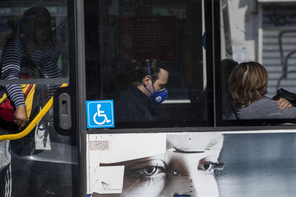 A man wears a face mask as he ride a bus in Tel Aviv, Israel, Sunday, March 15, 2020. Israel has imposed a number of tough restrictions to slow the spread of the new coronavirus. Prime Minister Benjamin Netanyahu announced that schools, universities, restaurants and places of entertainment will be closed to stop the spread of the coronavirus. He also encouraged people not to go to their workplaces unless absolutely necessary. (AP Photo/Oded Balilty)