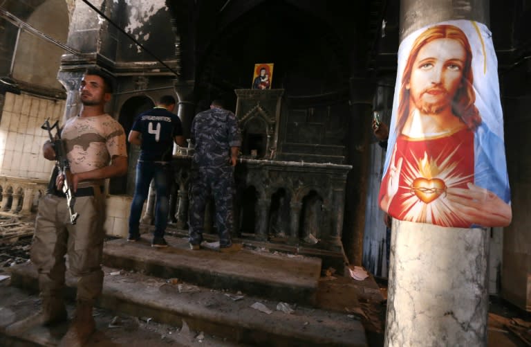 Iraqi Christian forces inspect the damage at the Church of the Immaculate Conception in the town of Qaraqosh, east of Mosul on October 30, 2016