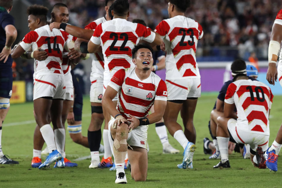 Japan's Kenki Fukuoka and teammates celebrate after winning over Scotland in the Rugby World Cup Pool A game at International Stadium in Yokohama, Japan, Sunday, Oct. 13, 2019. (AP Photo/Eugene Hoshiko)