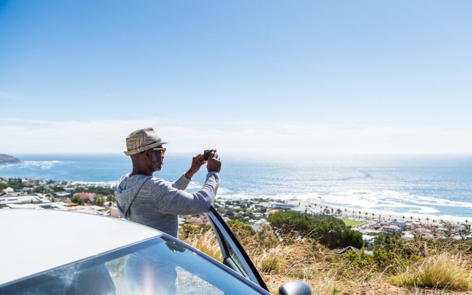 Tourists photographing the sea view with a smart phone