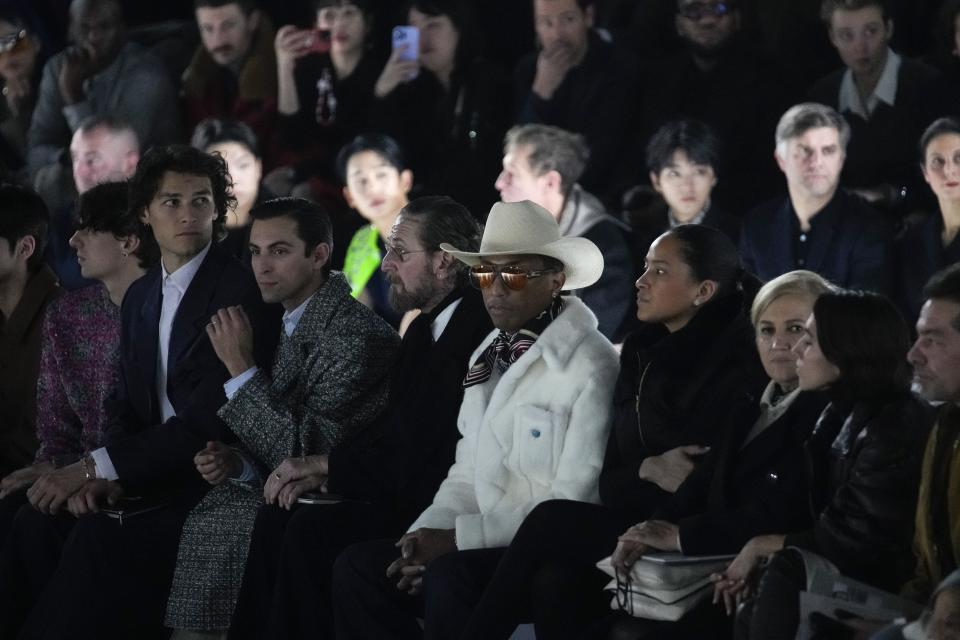 Pharrell Williams, centre, watches the Dior Menswear ready-to-wear Fall-Winter 2024-2025 collection presented in Paris, Friday, Jan. 19, 2024. (AP Photo/Christophe Ena)