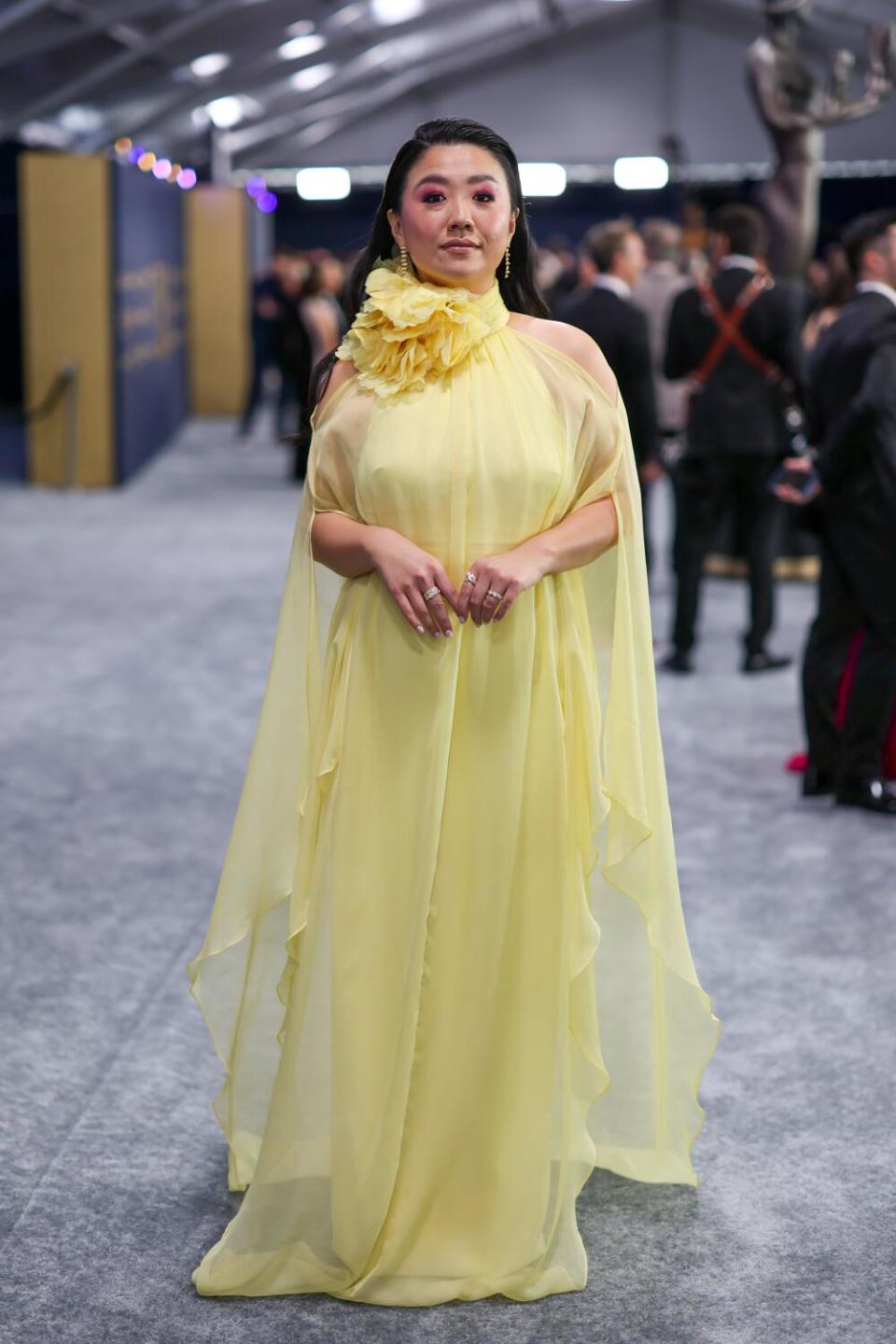 Sherry Cola wears a yellow cape dress at the SAG Awards.