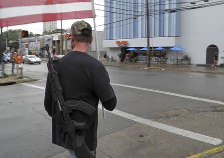 A pro-gun advocate walks down the street outside the University of Texas ahead of a 'mock mass shooting' event where they used cardboard cut-outs rifles, the simulated bangs of bullets on bullhorns and doused fake victims with fake blood, in Austin, Texas, December 12, 2015. REUTERS/Jon Herskovitz