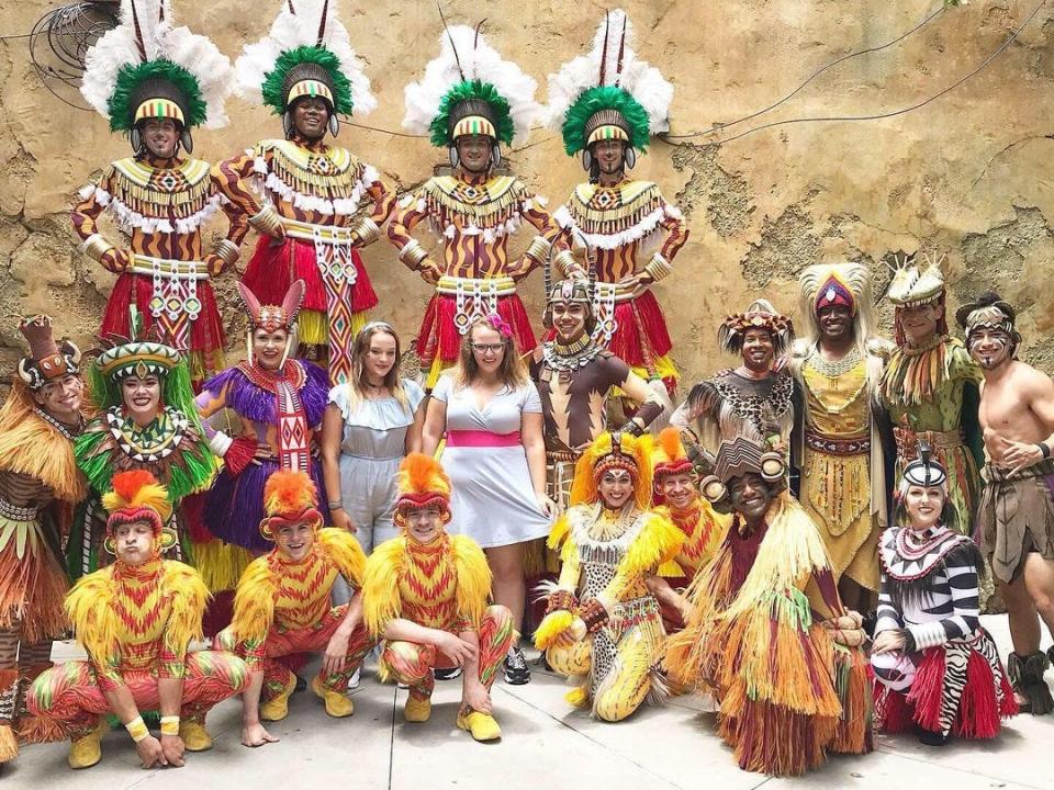casey posing with the cast of festival of the lion king at disney world