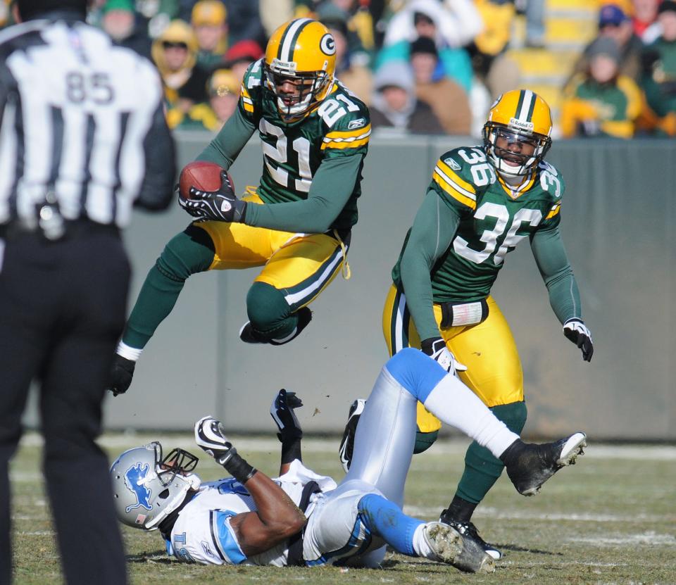 Packers defensive back Charles Woodson makes an interception above Lions receiver Calvin Johnson.