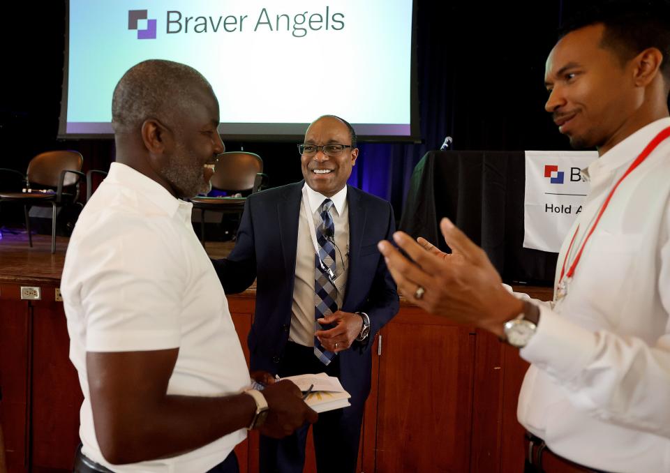 Ian Rowe, Elder Ahmad S. Corbitt and John Wood Jr. chat at the Braver Angels National Convention at Gettysburg College in Gettysburg, Pa.