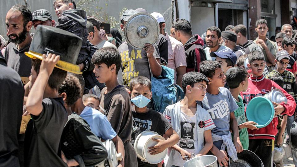 PHOTO: Men and children queue to receive food rations from a public kitchen in Deir el-Balah in the central Gaza Strip, May 13, 2024, amid the ongoing conflict in the Palestinian territory between Israel and Hamas. (AFP via Getty Images)