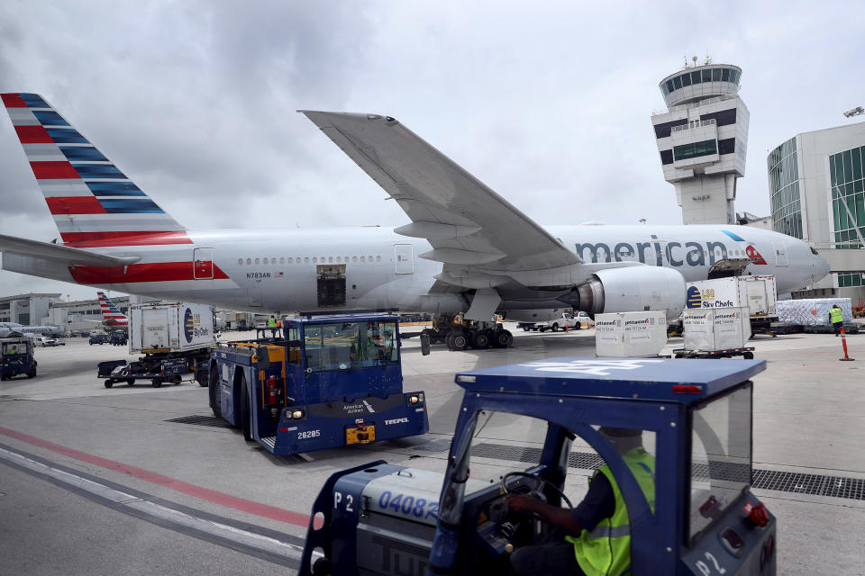 Image: Workers prepare an American Airlines plane at a gate before its flight from the Miami International Airport (Joe Raedle / Getty Images)