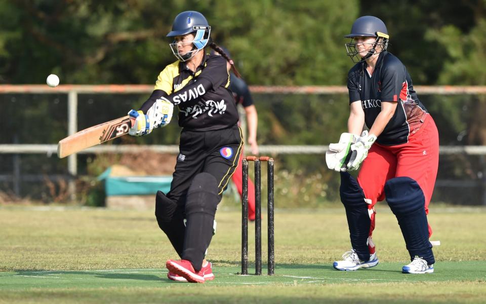 A member of the SCC Divas cricket team (L) batting against the Hong Kong Cricket Club Cavaliers in Hong Kong - PETER PARKS /AFP