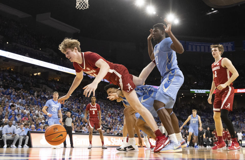 Alabama's Sam Walters, from left, falls over Creighton's Trey Alexander, center, and Fredrick King while chasing a rebound during the first half of an NCAA college basketball game Saturday, Dec. 16, 2023, in Omaha, Neb. (AP Photo/Rebecca S. Gratz)