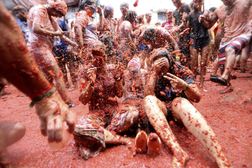 Revellers throw tomatoes at each other during the annual “Tomatina” tomato fight fiesta, in the village of Bunol near Valencia, Spain, Wednesday, Aug. 30, 2023. Thousands gather in this eastern Spanish town for the annual street tomato battle that leaves the streets and participants drenched in red pulp from 120,000 kilos of tomatoes. (AP Photo/Alberto Saiz)