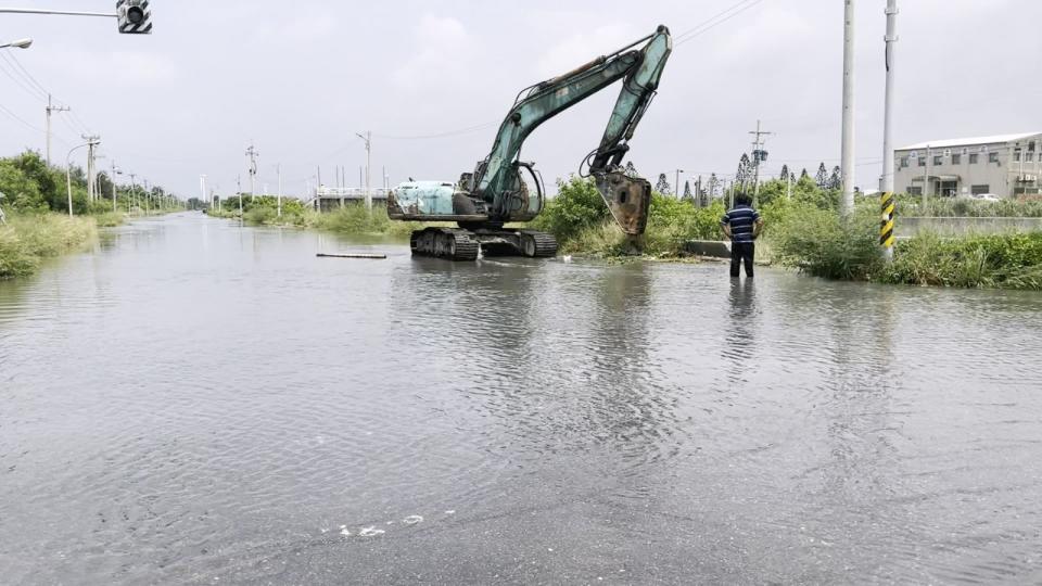 雲林口湖萡子寮漁港水淹小腿肚，怪手破壞橋邊護欄，讓積水流入河裡面。雲林縣政府提供