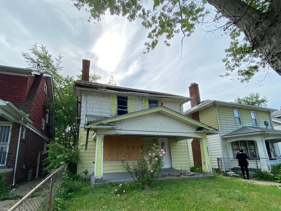 Detroit land bank authority yellow house with boarded up windows