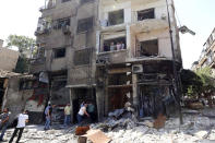 <p>Syrians inspect the damage at the site of a suicide bomb attack in the capital Damascus’ eastern Tahrir Square district, on July 2, 2017. (Louai Beshara/AFP/Getty Images) </p>