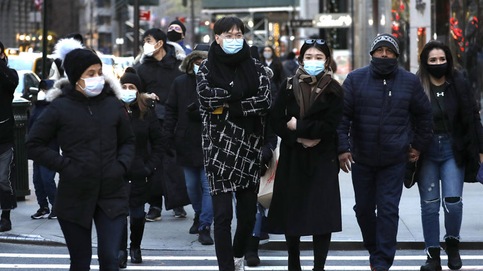 People wearing protective masks cross a street in Midtown on December 6, 2020 in New York City. (John Lamparski/Getty Images)