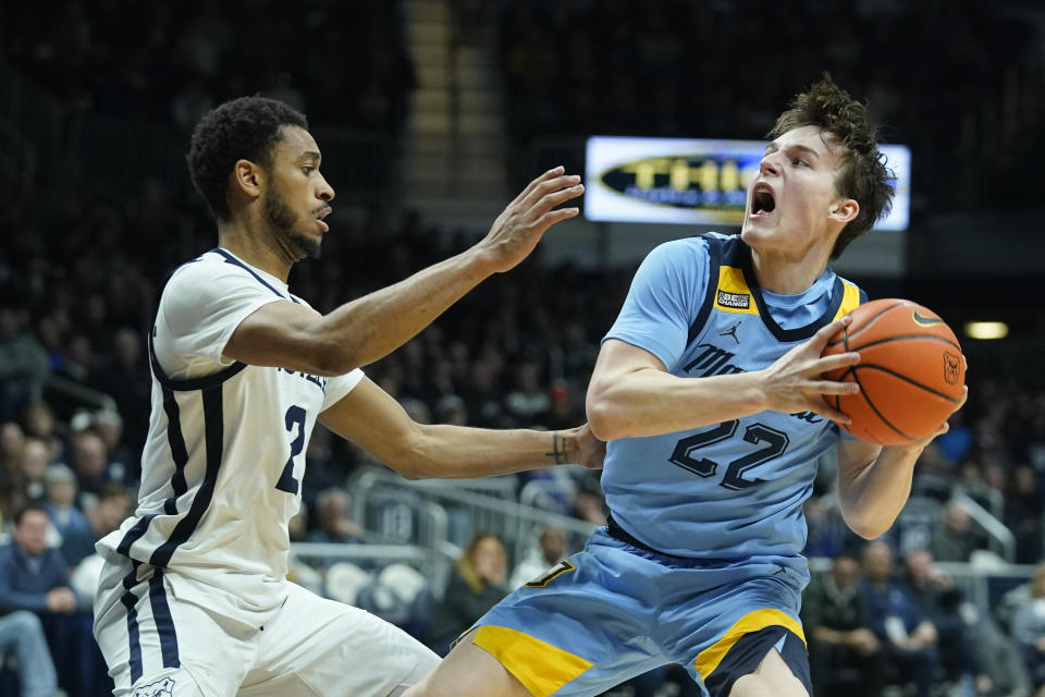 Marquette's Tyler Kolek (22) is defended by Butler's Aaron Thompson (2) during the second half of an NCAA college basketball game, Saturday, Feb. 12, 2022, in Indianapolis. (AP Photo/Darron Cummings)