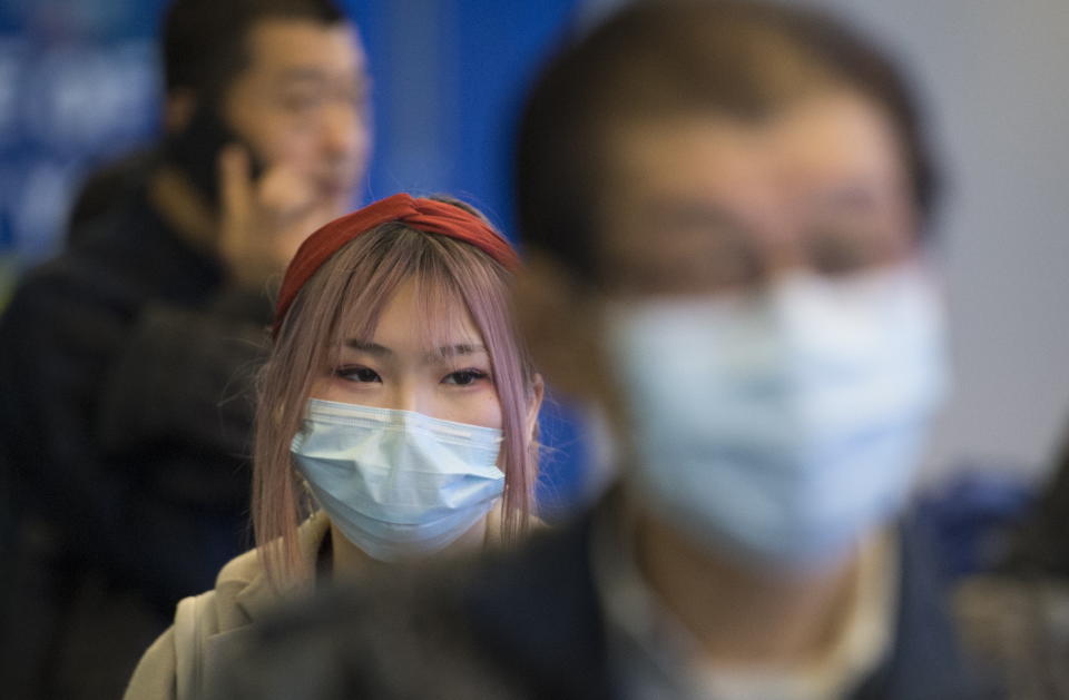 Passengers wear masks as they arrive at the international arrivals area at the Vancouver International Airport in Richmond, B.C., Thursday, January 23, 2020. THE CANADIAN PRESS/Jonathan Hayward