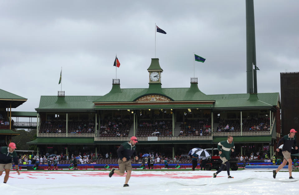 SYDNEY, AUSTRALIA - JANUARY 04: Grounds staff put rain covers over the wicket as play is delayed due to light conditions and rain during day two of the Men's Third Test Match in the series between Australia and Pakistan at Sydney Cricket Ground on January 04, 2024 in Sydney, Australia. (Photo by Mike Owen - CA/Cricket Australia via Getty Images)