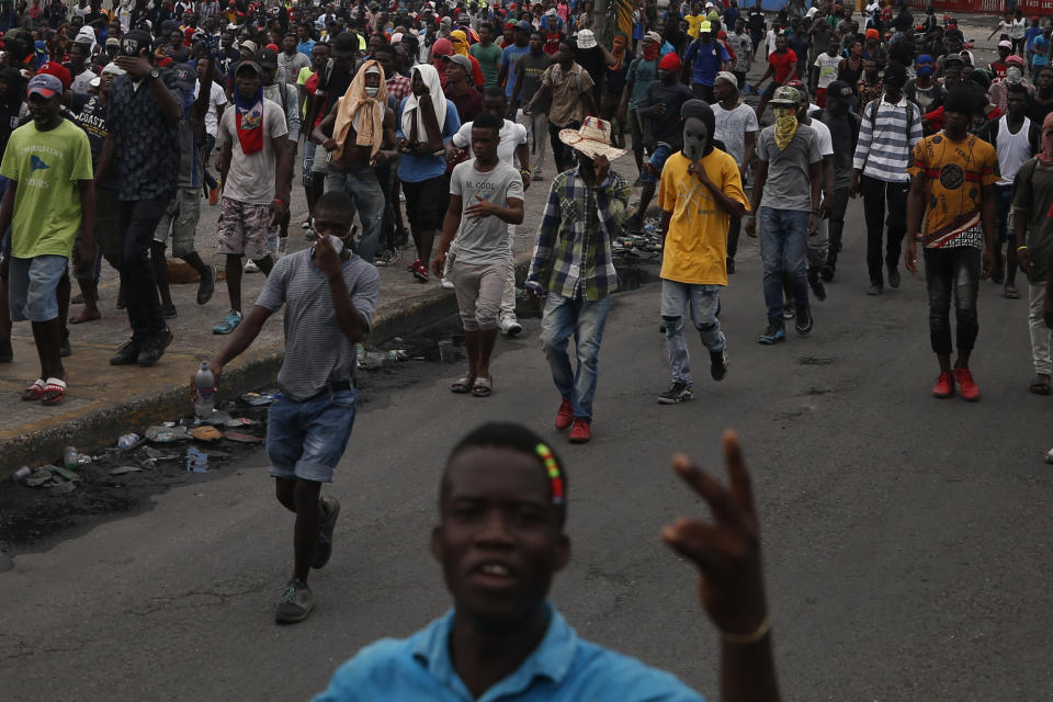 Protestors calling for the resignation of Haitian President Jovenel Moise march toward the National Palace before being stopped by police in Port-au-Prince, Haiti, Tuesday, Oct. 1, 2019. While there were sporadic demonstrations on Tuesday, another protest scheduled for Wednesday threatened to once again paralyze Haiti's capital and nearby communities, which have endured violent demonstrations for nearly a month as anger grows over corruption, spiraling inflation and dwindling supplies of food and gasoline. (AP Photo/Rebecca Blackwell)