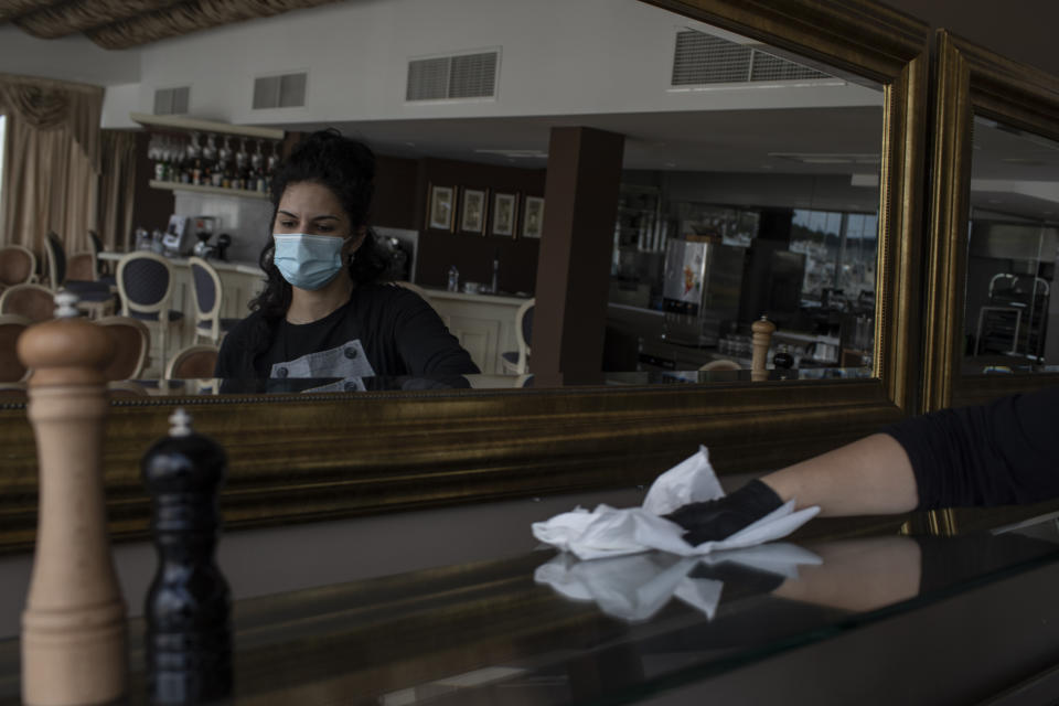 Hotel worker Nikoleta Vafiadou wearing a mask to reduce the spread of the coronavirus cleans at the Acropolian Spirit Hotel in central Athens on Monday June 1, 2020. Lockdown restrictions were lifted on non-seasonal hotels Monday as the country prepares to start its tourism season on June 15. (AP Photo/Petros Giannakouris)