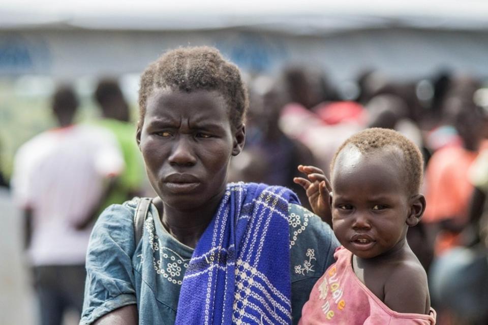 A young mother and her child on arrival at Kuluba Collection Point, near the border with South Sudan. "We walked through the bush for four days. My father is still in the village. He is too old to make the journey on foot," said Sarah A.&nbsp;<i>Location: Kuluba Collection Point, Nov. 1, 2016.</i>