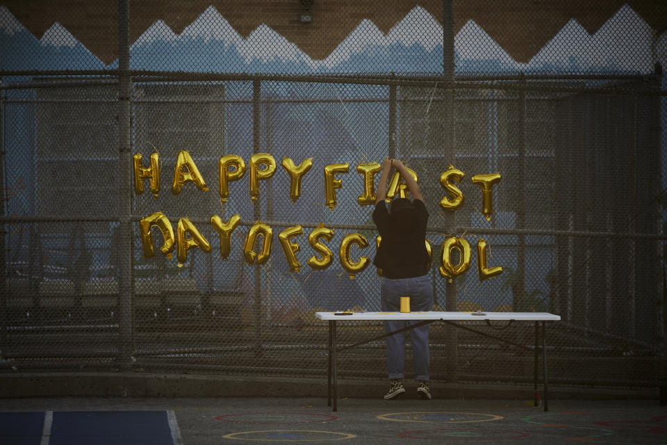 A school worker decorates the school yard where 5 year old Damien Salinas, attends on Thursday, Sept. 7, 2023 in New York. Damien attends his first day of school in New York City after his family emigrated from Ecuador in June. Damien and her family have been living in a room at the historic Roosevelt Hotel, converted into a city-run shelter for newly arrived migrant families hoping to find work, a new home and a better life for their children. (AP Photo/Andres Kudacki)