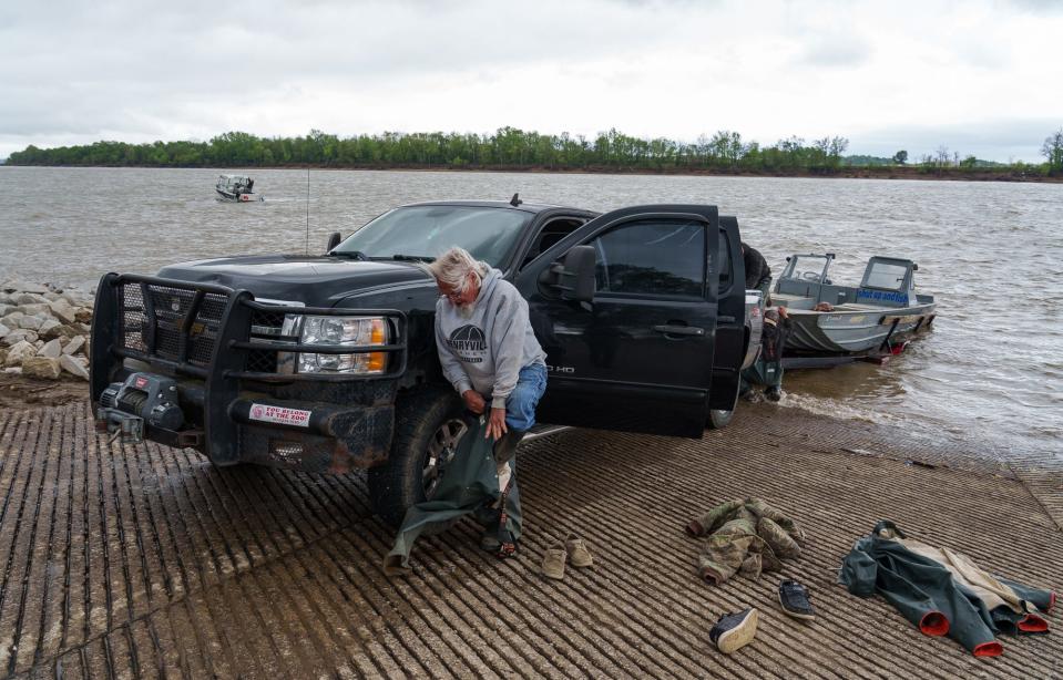 As his crew gets his boat into the Ohio River, fisherman David Cox puts on his rain gear, on a chilly and breezy Sunday, April 16, 2023, at the boat ramp in Troy, Indiana.