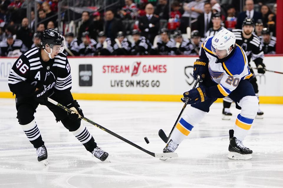 New Jersey Devils center Jack Hughes (86) fights for control of the puck with St. Louis Blues' Brandon Saad (20) during the second period of an NHL hockey game Thursday, Jan. 5, 2023, in Newark, N.J. (AP Photo/Frank Franklin II)